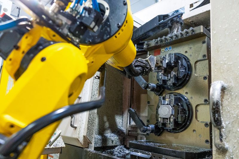 Das Bild zeigt eine Fanuc-Roboterzelle, die die automatische Be- und Entladung mehrerer Maschinen durch nur einen Bediener ermöglicht.