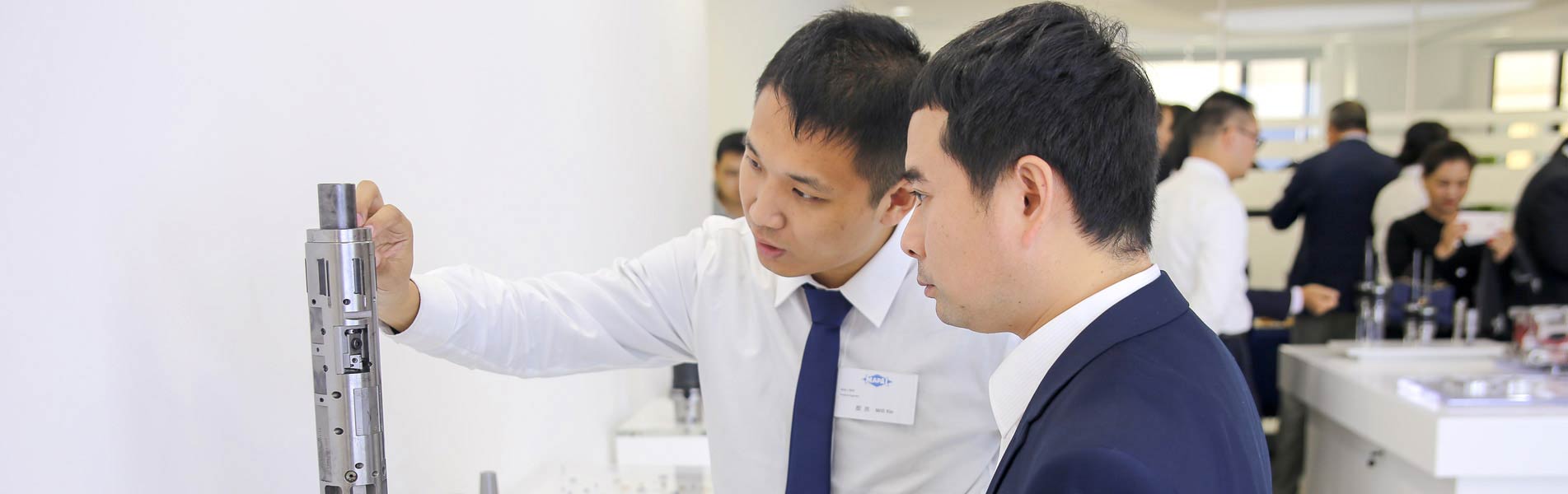 Ein Mitarbeiter von MAPAL China erläutert einem Kunden ein Werkzeug.
