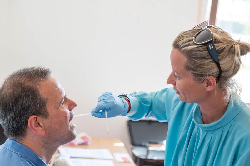 Doctor Sarah Strauch takes a cheek sample from MAPAL employee Robin Offinger