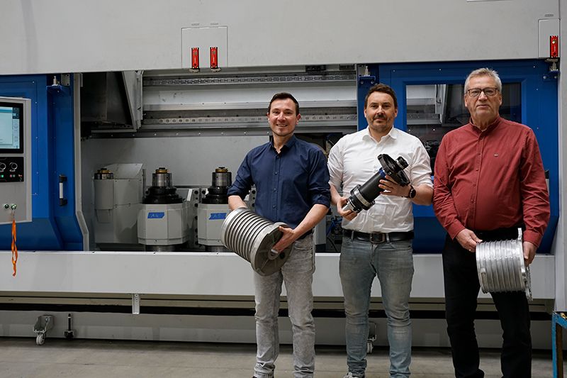 Daniel Pilz, André Ranke, and Thomas Lötzsch present a sample component, a fine boring tool, and a customer component.