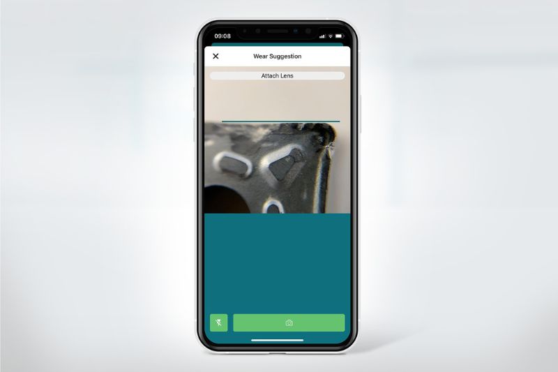 A mobile phone with an open c-Com wear and tear detection app with a photographed worn cutting edge.