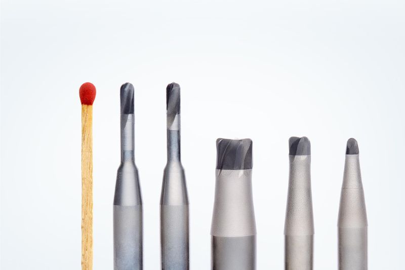 A selection of the new PCD solid head milling cutters compared in size with a match.