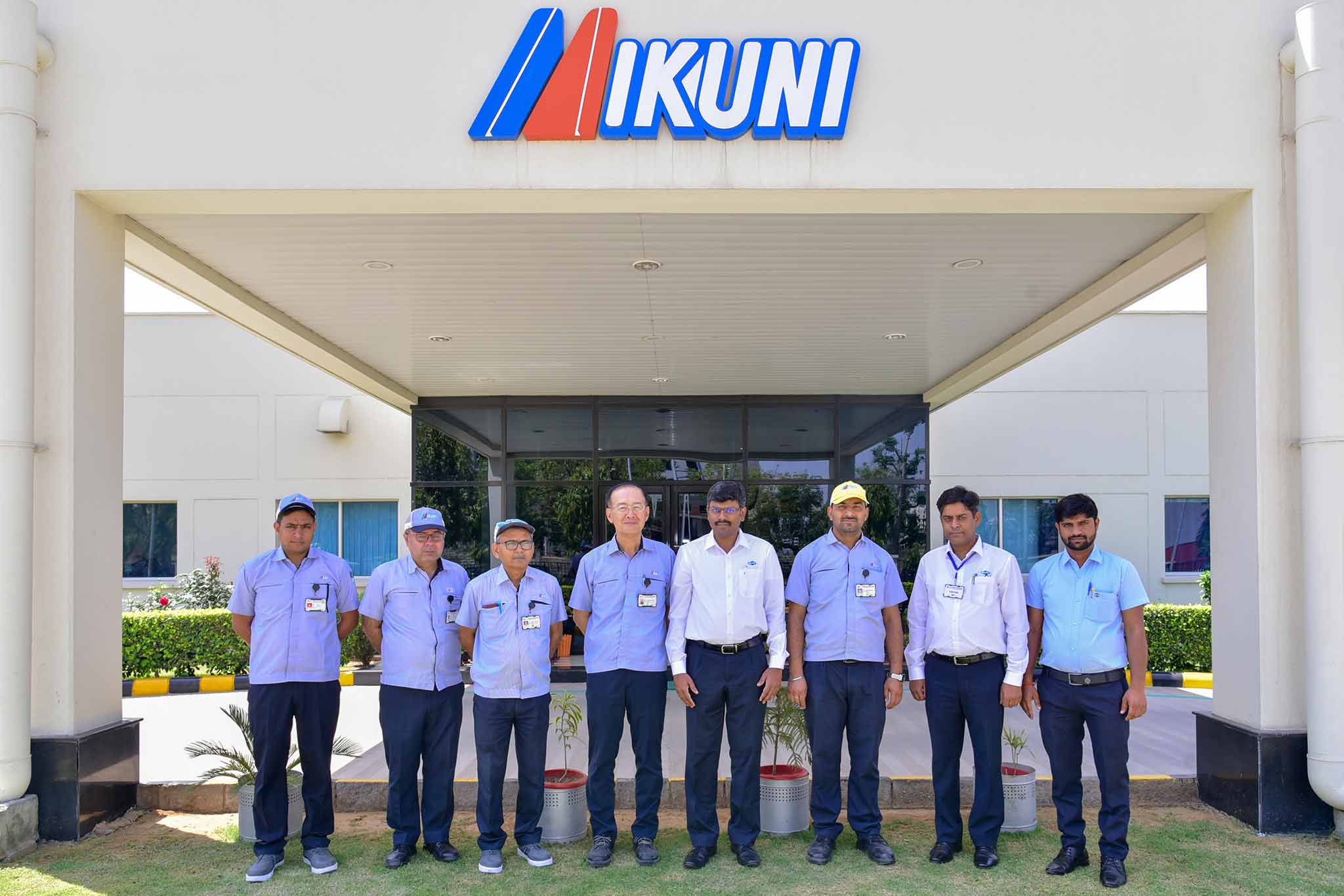 Die Teams von Mikunu und MAPAL, insgesamt acht Personen, stehen vor dem Gebäude von Mikuni India.