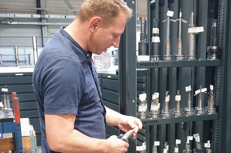 Matthias Hahn da MAPAL em frente a um armário vertical do sistema de distribuição UNIBASE.