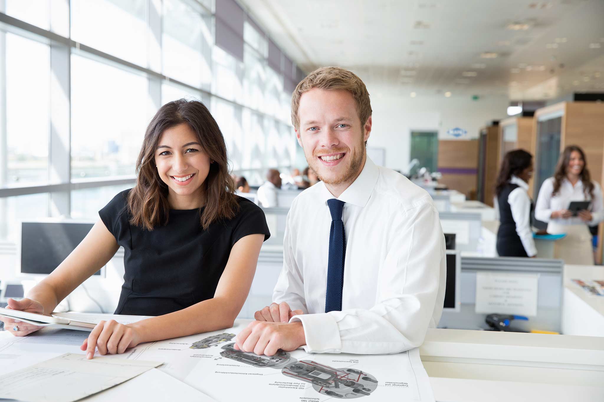 Two MAPAL employees at their desks can be seen in this picture.