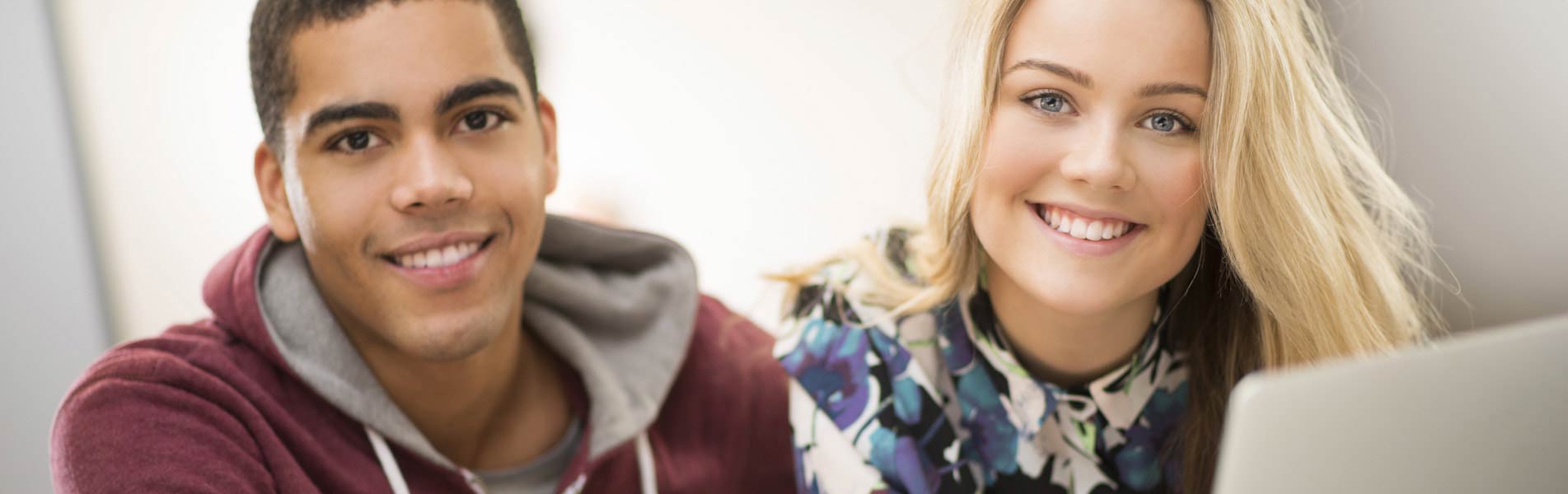 Two young people smile at the camera.