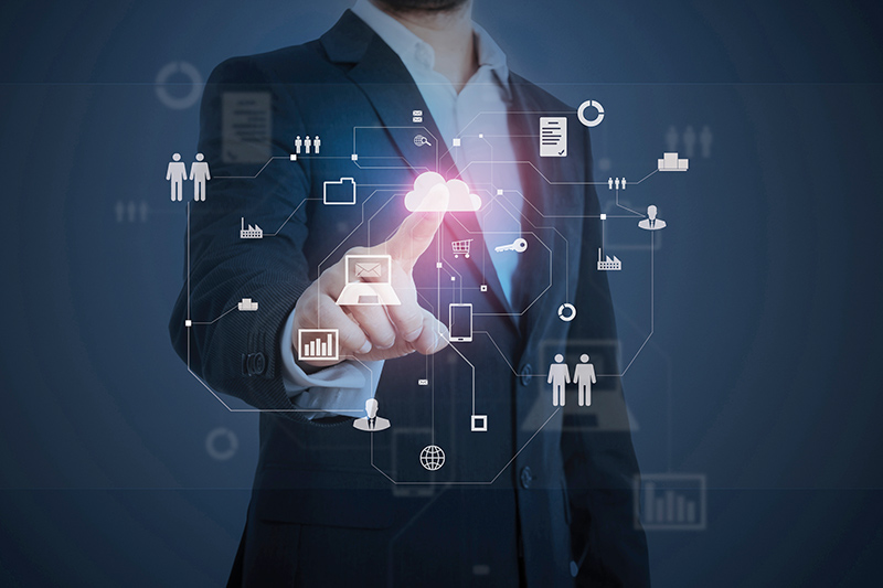 The image is a graphic illustration of digital connections between companies. The upper body of a man can be seen in the background, pointing at the graphic with his finger.
