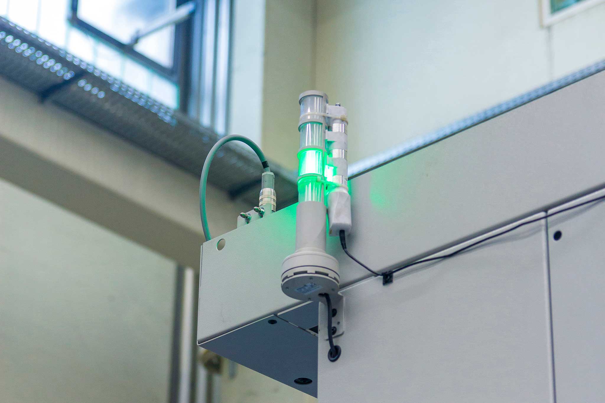 Die grün leuchtende Maschinenampel ist zu sehen. An sie angeschlossen sind Sensoren zur Überwachung.