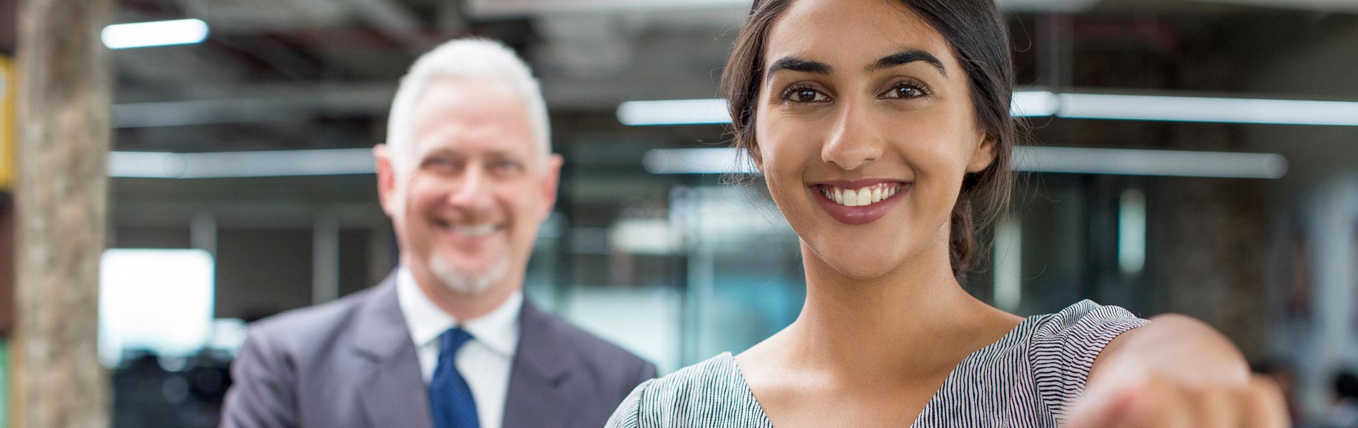 A young woman and a man look invitingly into the camera.