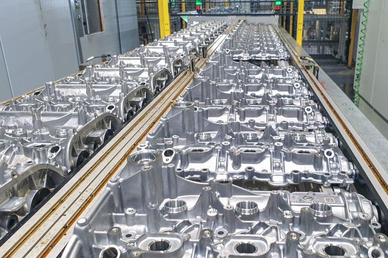 A imagem mostra uma grande quantidade de tampas de cabeçote da Schabmüller Automobiltechnik.